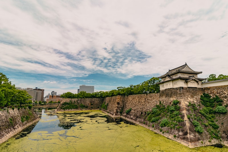 Osaka Castle white tower with moat and stone walls